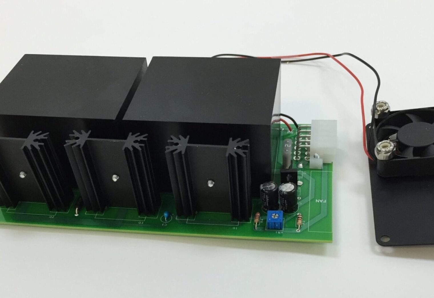 A green board with two black batteries and wires